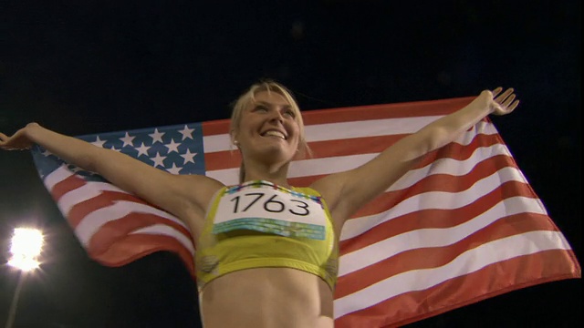在英国谢菲尔德赢得田径比赛后，LA MS Woman举着美国国旗视频下载