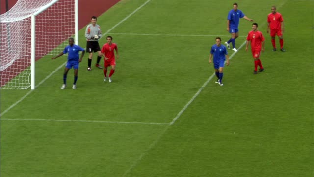 当球被扔进场地时，足球队员们挤在球门附近/红队队员头球进入球门/英格兰谢菲尔德视频下载