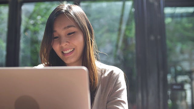 近距离观察亚洲女性在咖啡馆使用笔记本电脑视频素材