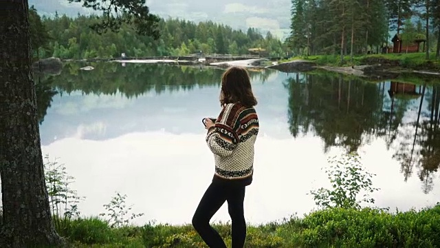 在挪威森林湖边喝茶的女人视频下载