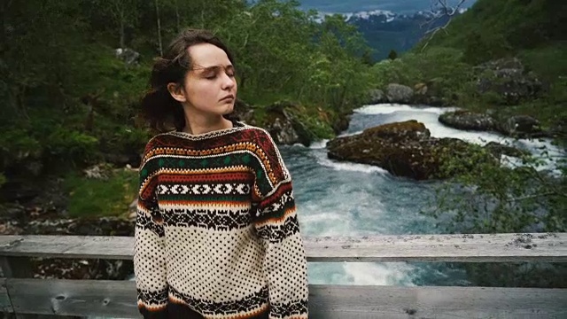 站在挪威山河木桥上的女子视频下载