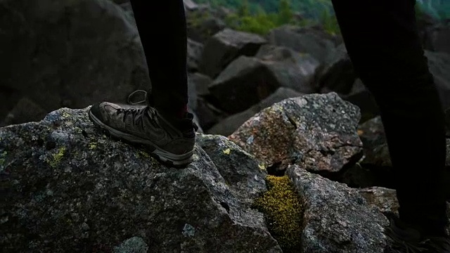 鞋子关闭。在岩石上徒步旅行的女人视频素材