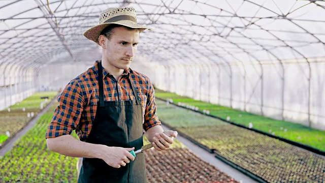 SLO MO DS的肖像，一个园丁与花园铲在温室视频下载