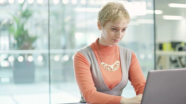 商业女性在办公桌上用笔记本电脑工作视频下载