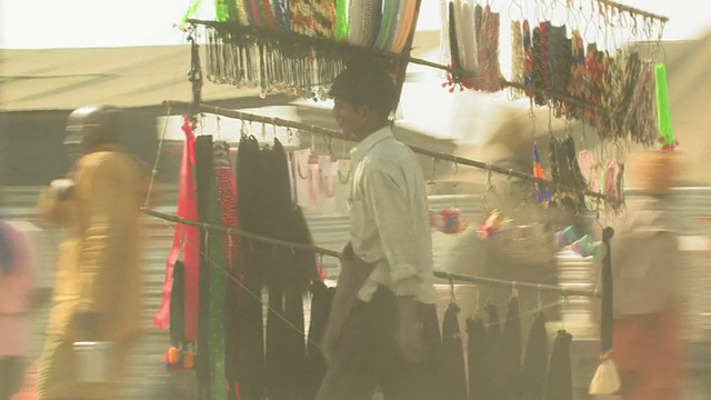 印度北方邦阿拉哈巴德，一名男子提着一大架珠宝穿过繁忙的街道，画面模糊视频素材