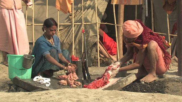 印度北方邦阿拉哈巴德，男人和女人在路边洗衣服，人们走在镜头前视频素材