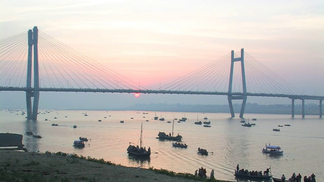 日出时分，印度北方邦阿拉哈巴德的第二亚穆纳桥下恒河上的船只视频素材