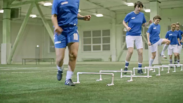 女子足球队队员跳过跨栏视频素材
