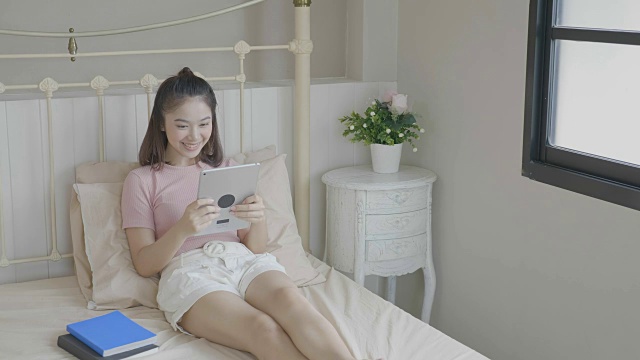 女人在床上用平板电脑视频下载