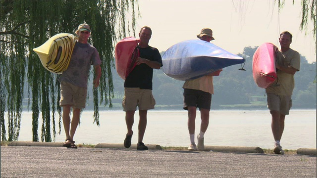 美国德克萨斯州湖边，四名男子背着皮划艇视频素材