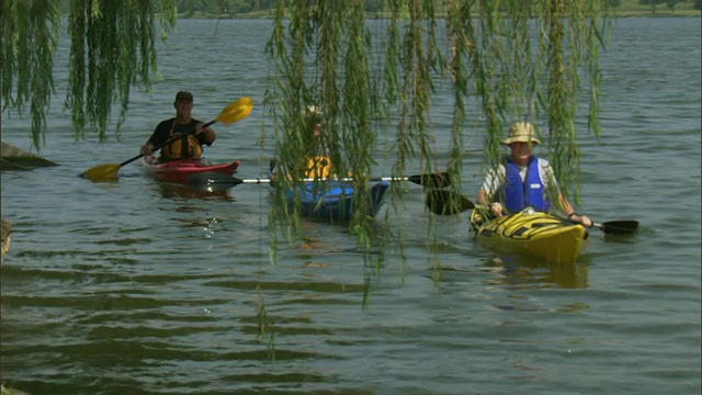 三名男子在湖附近划皮划艇/白石湖，达拉斯，德克萨斯州，美国视频素材