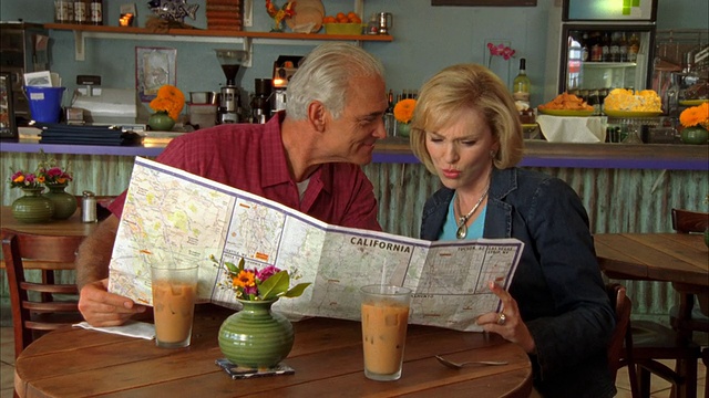 美国加州摩洛湾，一对成年夫妇正在咖啡馆里看地图，视频素材