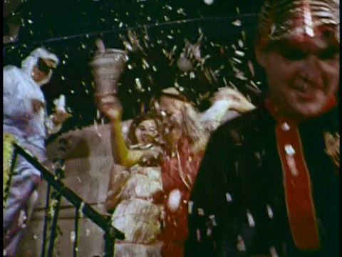 Mardi Gras狂欢节的狂欢者们一边走下楼梯，一边投掷五彩纸屑视频素材