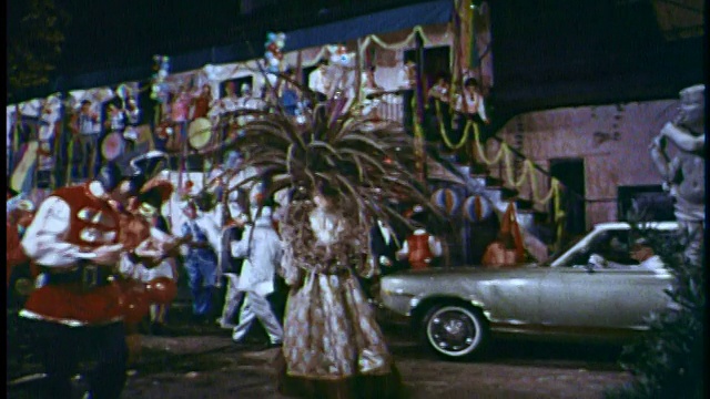 在美国，一名戴着羽毛面具的狂欢节狂欢者转身走向其他狂欢者视频素材
