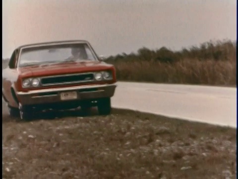蒙太奇WS红色1967 AMC漫步者Rebel在两条车道的道路上俯冲，当汽车进入它的车道以超过另一辆汽车/漫步者驶离道路，以避免迎面驶来的汽车返回道路/美国视频素材