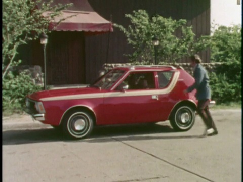 蒙太奇WS ZO夫妇跑出大楼，进入红色1973 AMC Gremlin/ WS汽车开车离开，后面是刚结婚的标志/美国视频下载