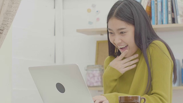 美丽的亚洲女性在咖啡馆用笔记本电脑工作视频下载