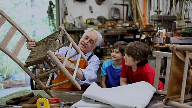 孙子在车间里，爷爷在修理古董家具。视频下载