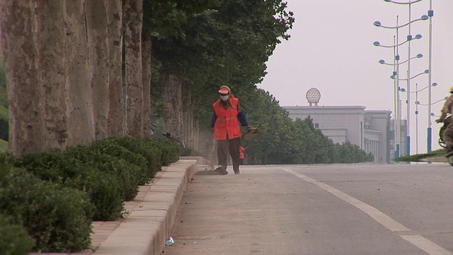 当车辆经过时，两名清洁工在路边工作/济南，中国视频下载