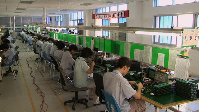 中国深圳，在电子厂的一排排桌子前工作的WS PAN人视频下载