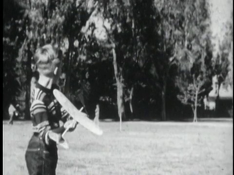 两个男孩玩模型飞机/男孩旋转螺旋桨/男孩飞行玩具飞机穿过院子/美国视频下载