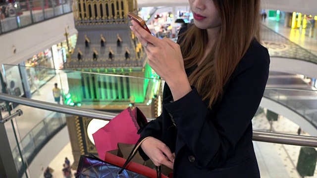 女人用购物袋在智能手机上购物视频素材