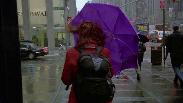 中景女子撑着雨伞在纽约的人行道上行走视频下载