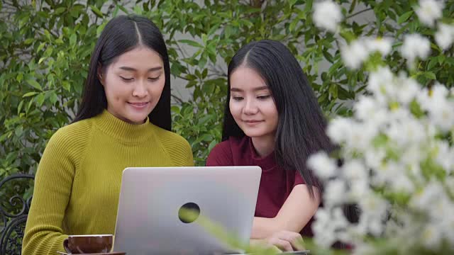 两个年轻女子惊讶地看着笔记本电脑视频下载