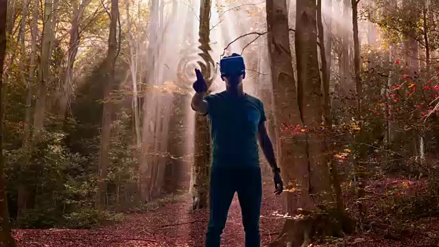 盖伊体验虚拟现实头盔沉浸在另一个维度触摸和感受树木的维度场景运输在一个美丽的自然森林。视频下载