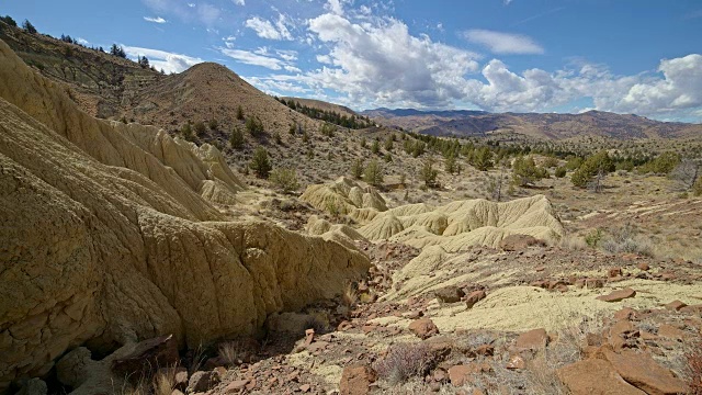 不毛之地黄色粘土约翰戴化石床的形成云和阴影漂移在一个偏远的沙漠山萨顿山靠近画山6视频素材