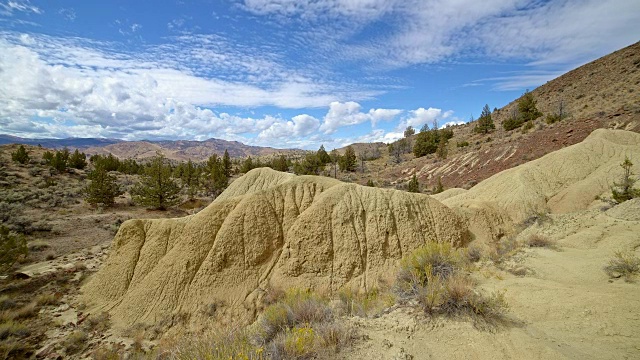 不毛之地黄色粘土约翰戴化石床的形成云和阴影漂移在一个偏远的沙漠山萨顿山靠近画山7视频素材