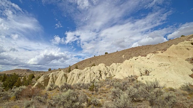 不毛之地黄色粘土约翰戴化石床的形成云和阴影漂移在一个偏远的沙漠山萨顿山靠近画山13视频素材