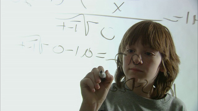 CU男孩在玻璃上用记号笔写数学等式/纽约市视频下载