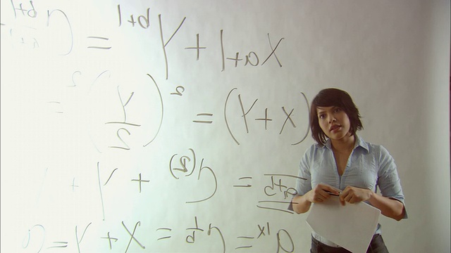 MS Woman满意地看着写在玻璃上的数学等式/纽约市视频下载
