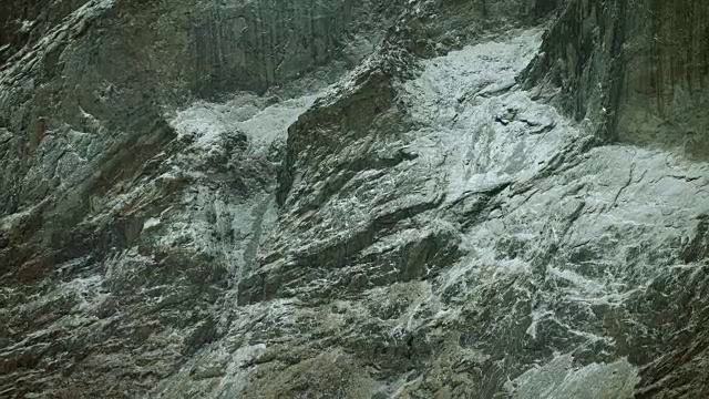 近距离拍摄的雪花飘落的石崖视频素材