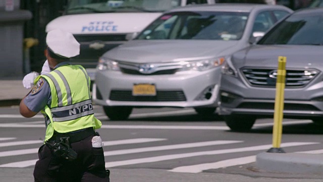 在炎热的夏天，交警在纽约市繁忙的十字路口指挥交通。视频素材