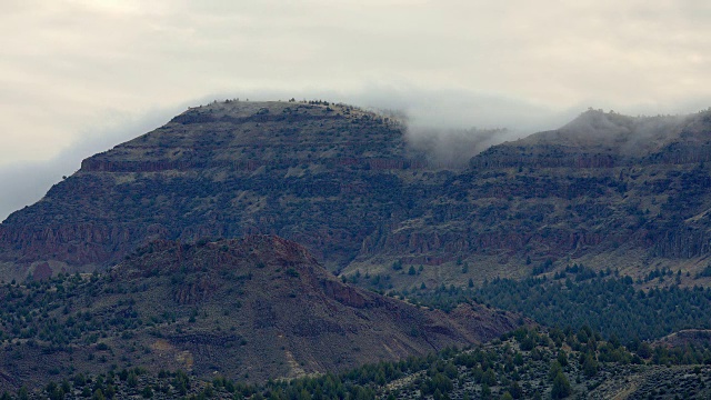黎明的雾和云翻滚在多岩石的沙漠山萨顿山附近的山丘视频素材