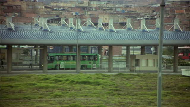 哥伦比亚波哥大公交站附近的道路上行驶着WS PAN TransMilenio公交车视频素材