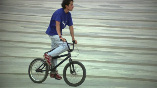 哥伦比亚波哥大城市公园里骑自行车和做前轮特技的男孩视频下载