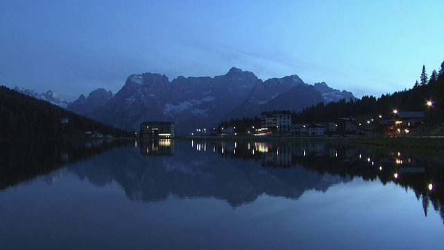 意大利阿尔卑斯山Dolomites, WS, Sorapis山和建筑反射在黄昏的米苏里纳湖上视频下载