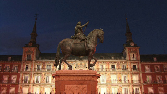西班牙马德里市长广场，佩利佩三世的骑马雕像和潘德里亚之家在黄昏的灯光背景下视频素材