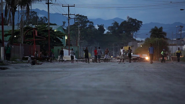 黄昏时在街道上的WS TILT UP触摸橄榄球/巴布亚新几内亚视频下载