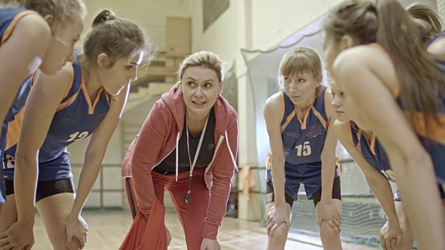 女教练鼓动篮球队站成一圈视频素材