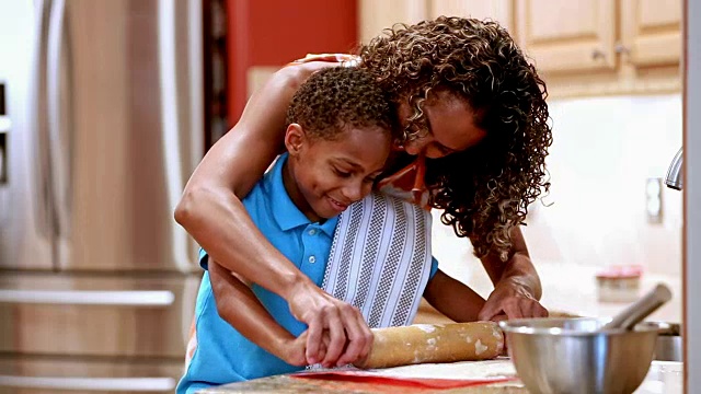 母亲和儿子在厨房烤饼干。视频素材