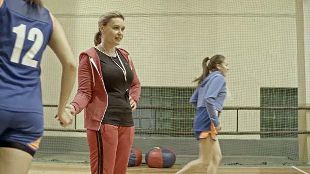 教练在训练中支持女篮球运动员视频素材