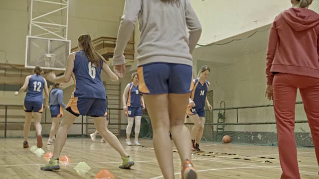女运动员在教练指导下进行篮球训练视频素材