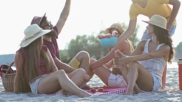 年轻的朋友们在海滩上吃西瓜视频下载