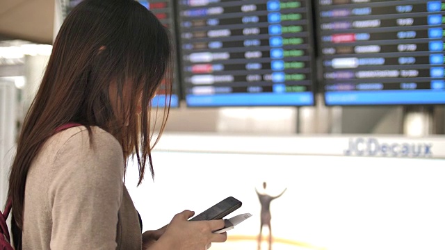 一名女子在机场用智能手机检查登机牌视频下载