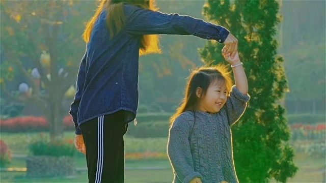 年轻的母亲和女儿在公园里玩视频素材