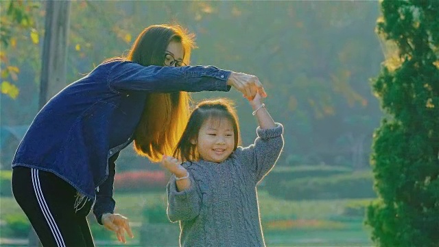 年轻的母亲和女儿在公园里玩视频素材